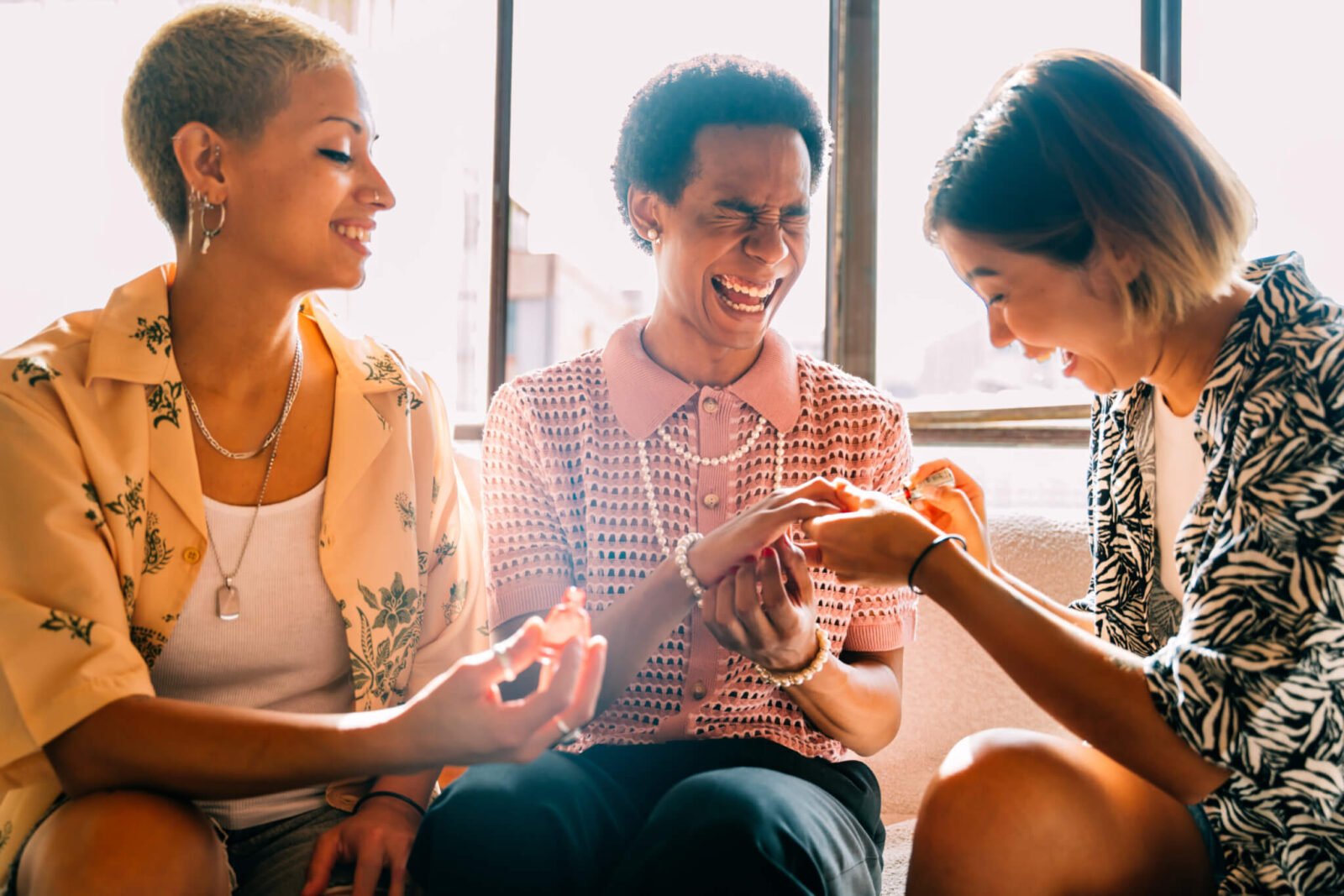 group of friends painting nails and laughing