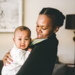 This is a photo of a Black woman holding a baby.