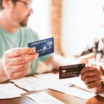 A couple sits at the kitchen table reviewing their monthly bills as they discuss the Best Debt Repayment Methods