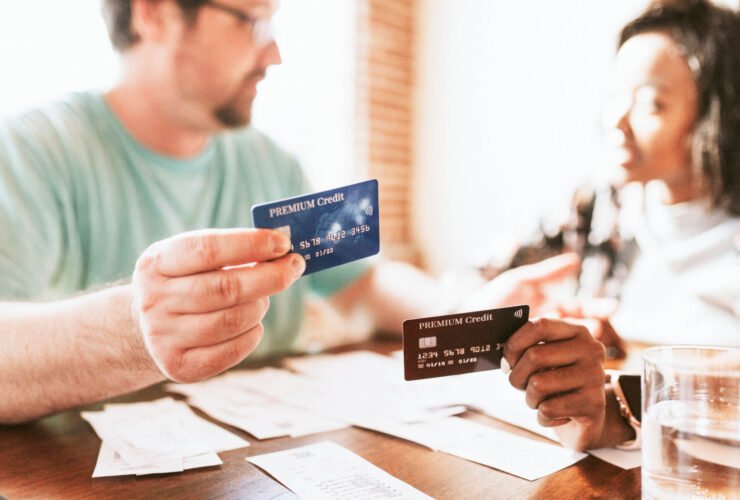 A couple sits at the kitchen table reviewing their monthly bills as they discuss the Best Debt Repayment Methods