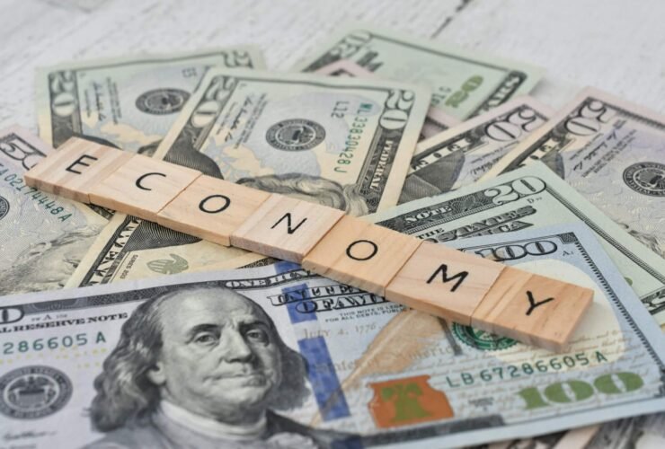 The word economy spelled out over a pile of money.