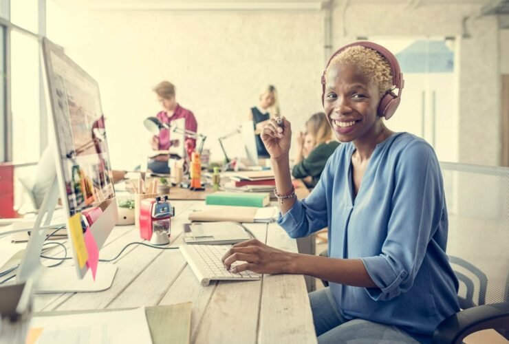 women siting in front of a computer with headphones on