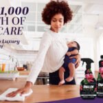 Image of a Black woman in a white shirt holding a baby cleaning a kitchen countertop with a white cloth. In the foreground are Pinalen Luxury Scents cleaning products. Text reads "Win $1,000 worth of self-care Adding a little luxury to the everyday Pinalen Luxury Scents"
