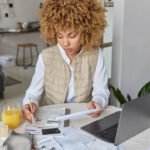 woman sits at table and balances her budget