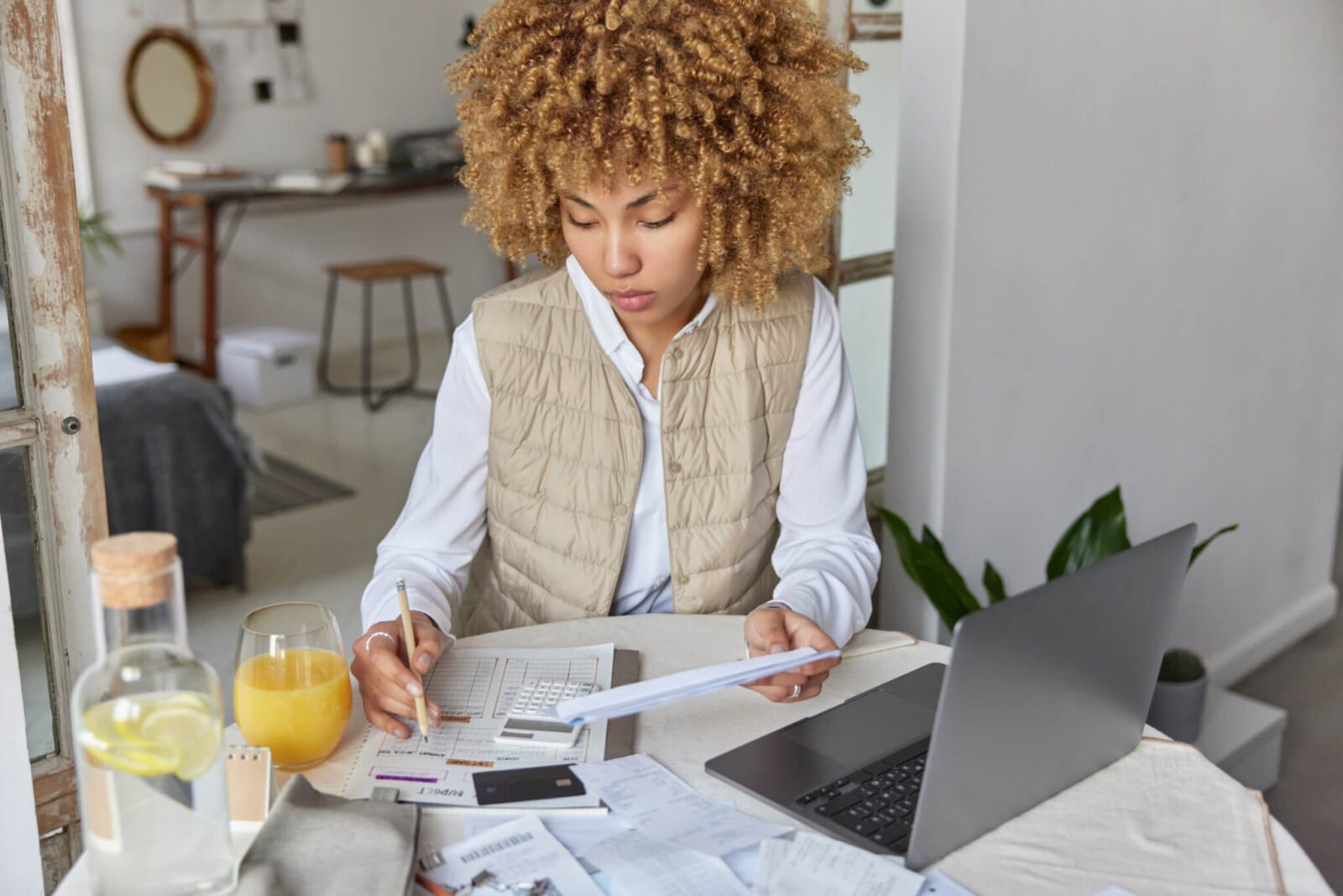 woman sits at table and balances her budget