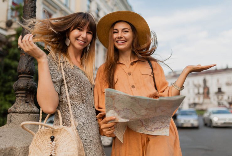 two gen z women looking at a map while traveling