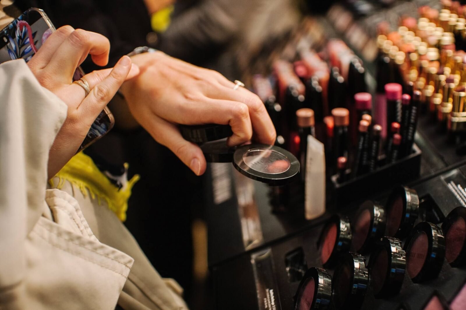 This is a close up of a woman shopping for makeup and testing it on her hand.