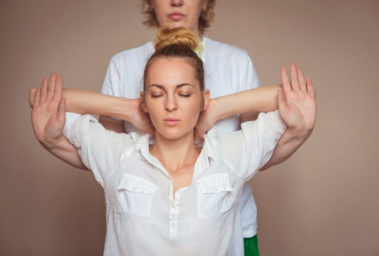 chiropractor working on woman putting arms behind the head