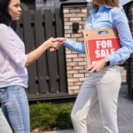 young couple shaking hands with real estate agent