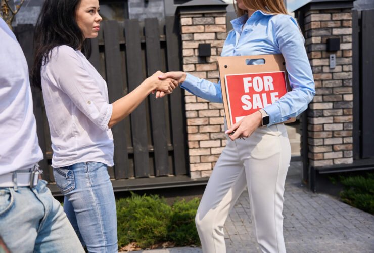 young couple shaking hands with real estate agent