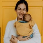 Smiling woman holding her baby.