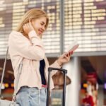 Girl in a airport. Blonde with a documents. Lady in a black t-shirt