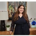Sami Sage of Betches Media stands and smiles at the camera wearing a black dress.