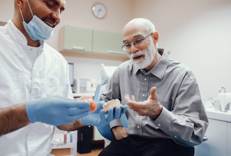 Handsome old man talking to the dendist. Two men in the dentist