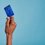 Close up of a woman's hand holding a bank credit card to make a payment with her first credit card